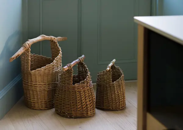 Three handwoven baskets with raw wooden handles on the kitchen floor provide a rustic farmhouse kitchen feel in this Scottish kitchen project.